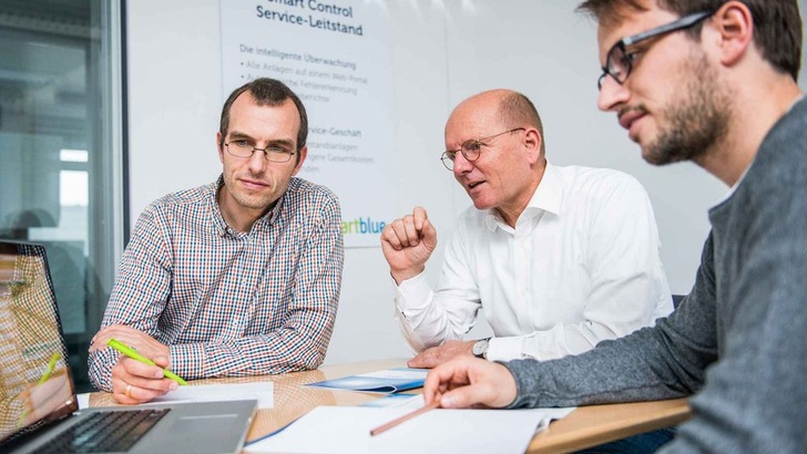Diskussion erlaubt: Smartblue-Chef Günter Seel (Mitte) in einer Besprechung mit zwei Mitarbeitern. - © Smartblue
