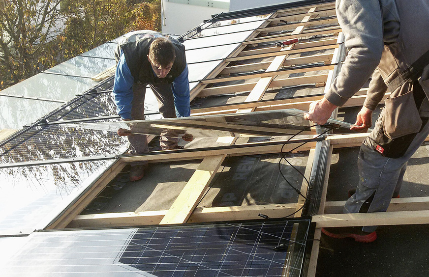 Die Module werden auf die Unterkonstruktion des Daches montiert. Vorher schaffen die Handwerker eine Hinterlüftungsebene, wo die Wärme gesammelt wird.