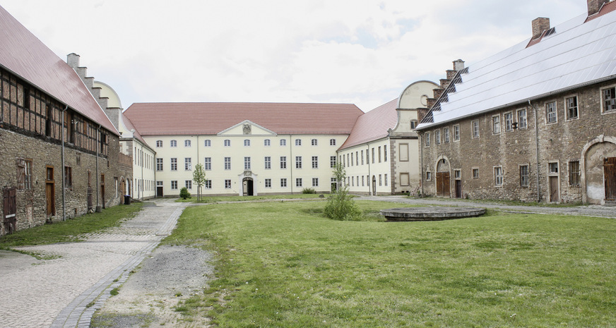Blick auf das Haupthaus und den Schlosshof, von zahlreichen Gebäuden flankiert: Remter, Ställe, Wohnungen.