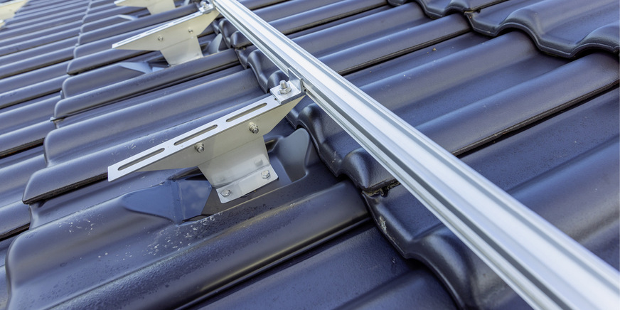 Die Schienen für die Unterkonstruktion werden über den Langlöchern ausgerichtet und mit Hammerkopfschrauben befestigt.