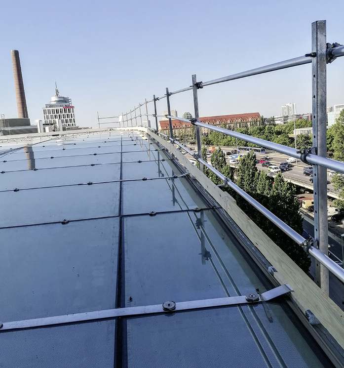 Die Halteplatte wird am Dachrand angebracht. Per Schwenkbewegung werden die Gerüstteile fixiert.