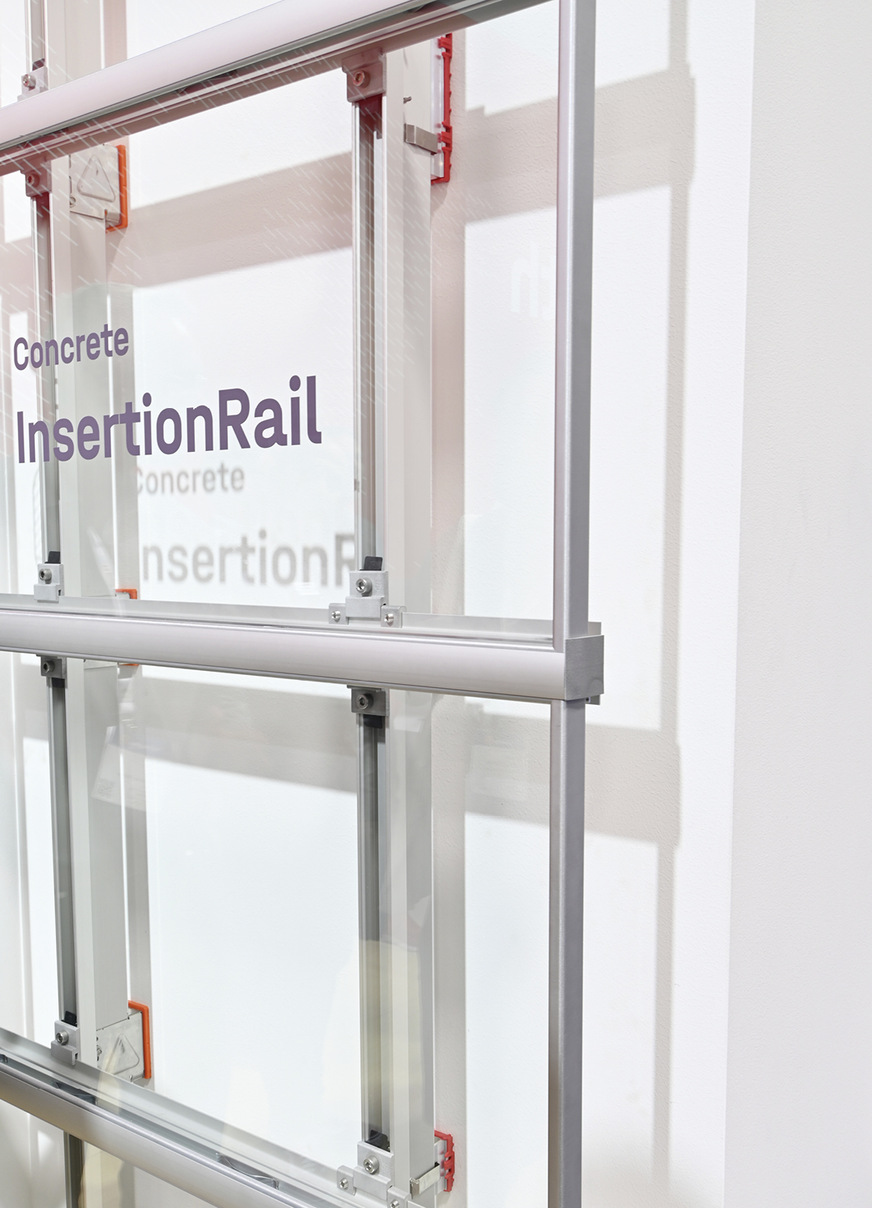 Die Befestigung an der Betonfassade ist über handelsübliche zugelassene Konsolen gelöst. Für eine dickere Dämmung kann der Kragarm auch länger sein. Wärmebrücken werden durch zusätzliche Kunststofffüße (rot) vermieden.