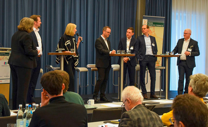 Klaus Müller (in der Mitte am Tisch) bei der Diskussion auf der Tagung Zukünftige Stromnetze 2025.