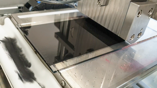 Die Schlitzdüse bringt eine Kohlenstoffschicht auf das Glassubstrat auf. Nacheinander werden so alle fünf Schichten der Solarzelle aufgebracht.