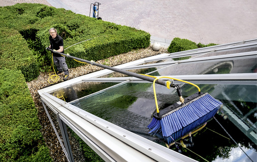 Reinigung des Daches eines Wintergartens. Das könnten ebenso gut Solarmodule sein.