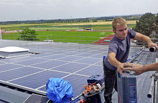 
Handwerker packen zu: Abschluss der Sanierung des Daches einer Turnhalle in Zülpich. Das Asbestdach wurde durch Trapezblech und Solarmodule ersetzt.
