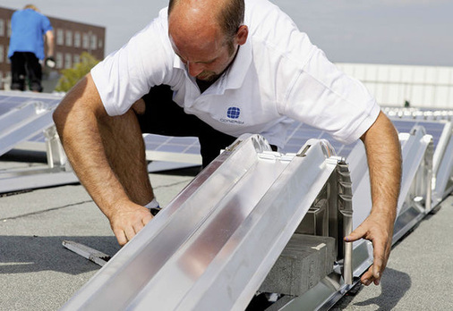 
Montage des Solar Famulus Air: Die Betonsteine, mit denen die Anlage ballastiert wird, sind genormt. Wenn der Monteur und der Planer immer den ermittelten Mindestballast auflegen, kann nichts schiefgehen. Allerdings wird die Anlage unter Umständen sehr schwer. Das könnte statische Probleme im Dach zur Folge haben.
