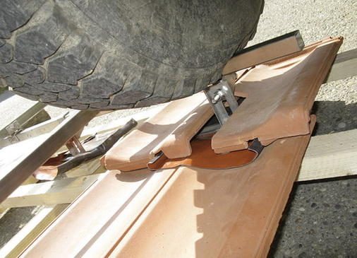 
An diesem Foto sieht man sehr gut, dass sich der Haken unter der Last auf der Modulschiene nicht verformt. Demzufolge bleiben auch die Ziegel unbelastet, sie brechen nicht.
