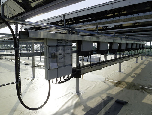 
Installation von Wechselrichtern unter den Montagegestellen eines Solarkraftwerkes. Auch die Zähler und Sicherungen für den AC-Anschluss sind übersichtlich angeordnet und leicht zugänglich.
