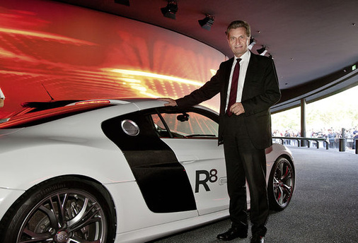 
Der unter Verfechtern des deutschen EEG umstrittene EU-Energiekommissar Günther Oettinger mit dem Audi R8 e-tron auf der 64. IAA.
