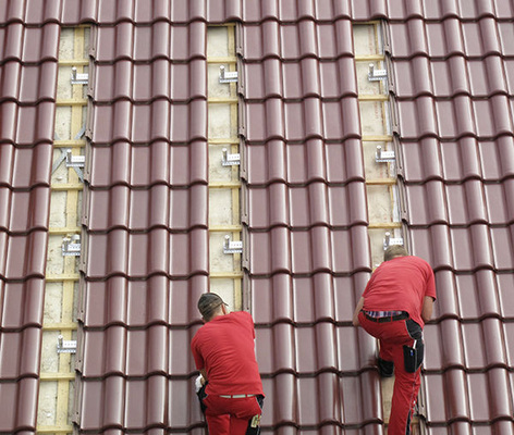 
Effektive Montage: Nachdem die Positionen festgelegt sind, werden die Solarhalter auf den Dachsparren gesetzt. Sie halten später die Solaranlage sicher über den Ziegeln.

