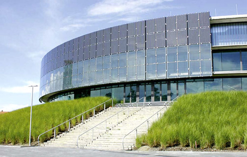 
Im oberen Teil besteht die Fassade aus Solarmodulen, der untere Bereich wurde transparent ausgeführt. Auf diese Weise gelangt viel Tageslicht ins Foyer der Arena.
