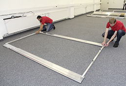 
Im Competence Center von IBC Solar. Die Monteure Andreas Ullrich und Tobias Zipf nutzen eine Montagelehre zum Ausrichten der Bodenschienen.
