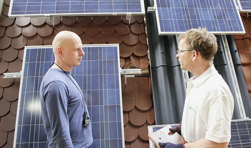 <p>
Ein Redakteur der
 photovoltaik 
lässt sich beim Montagetest unterschiedliche Halterungen erklären.
</p> - © Foto: William Vorsatz

