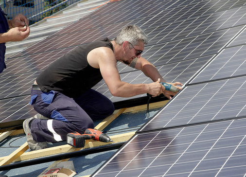 <p>
Dieser Installateur wird durch Fangzäune an der Dachkante abgesichert. Allerdings fehlt ihm ein Schutzhelm. Und: Die starke Sonneneinstrahlung auf dem Dach erhöht das Risiko von Hautkrebs.
</p> - © Foto: Schott Solar

