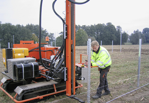 
Das Einbringen der Profile in den Boden erfolgt mit Hydraulikrammen. Je nach Bodenklasse werden die Pfosten circa anderthalb bis zwei Meter tief in die Erde gerammt.
