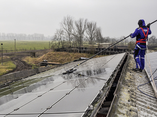 <p>
Mangels Sekuranten sichern sich die Mitarbeiter bei der Reinigung an den Befestigungen der aufgeständerten Anlagenteile auf der rückwärtigen Dachhälfte.
</p>