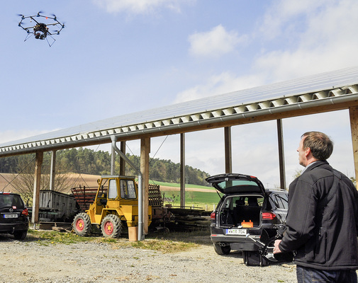 



Vor-Ort-Termin in Herbsen. Thomas Reusch überfliegt mit seinem Oktokopter eine Dachanlage. An der Unterseite sind eine Thermografiekamera und eine Echtbildkamera montiert.
