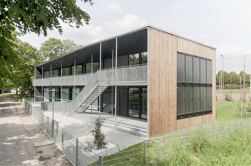 
Der Laubengang mit dem weit vorgezogenen Dach verhindert die sommerliche Überhitzung der Räume. Und er schafft zusätzlichen Raum für die Begegnung der Schüler und Lehrer.
