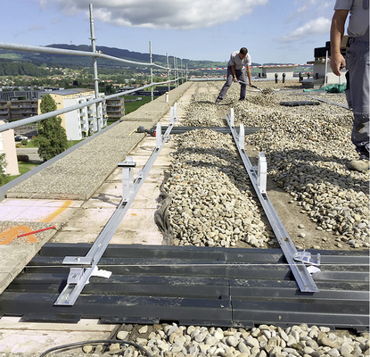 



Mit den Solrec-Platten haben die Handwerker eine ebene Montagefläche und gleichzeitig eine Möglichkeit geschaffen, die Anlage auf dem Dach anzuschrauben. Die Module sollten auf dem Kies aber nicht abgestellt werden.
