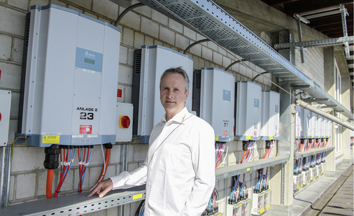 <p>
</p>

<p>
Erich Stutz von der Fuchs Wohnbau AG steht vor den außen installierten Stringwechselrichtern.
</p> - © Foto: Fuchs Wohnbau AG


