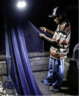 



Ein Fischer flickt sein Fangnetz.
