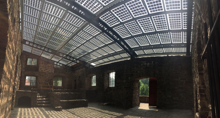 143 Elegante-Module auf der Herrenhausruine des denkmalgeschützen Wasserschlosses Wülmersen produzieren jährlich rund 25.000 kwh/a Strom. Durch die großflächige Verwendung von Elegante entstehen in der Halle einzigartige Lichteffekte. - © aleo solar GmbH