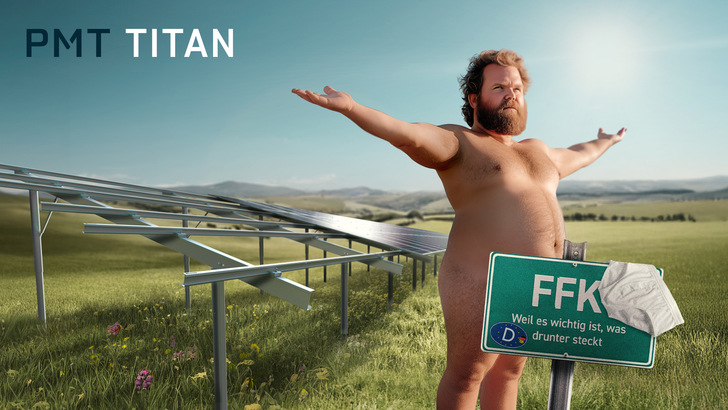 Ein bärtiger Mann steht nackt mit ausgestreckten Armen in der Nähe von Sonnenkollektoren auf einem Feld; auf einem Schild steht "FFK. - © PMT 2025