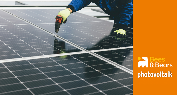 Person bei der Installation von Solarmodulen mit einer Bohrmaschine, rechts das Logo von Bees & Bears Photovoltaik auf orangem Hintergrund. - © Bees&Bears