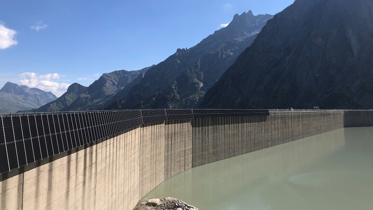 Ein großer Teil der Anlage hängt schon: Aufgrund des guten Wetters kommen die Bauarbeiten am Staudamm gut voran. - © EWZ
