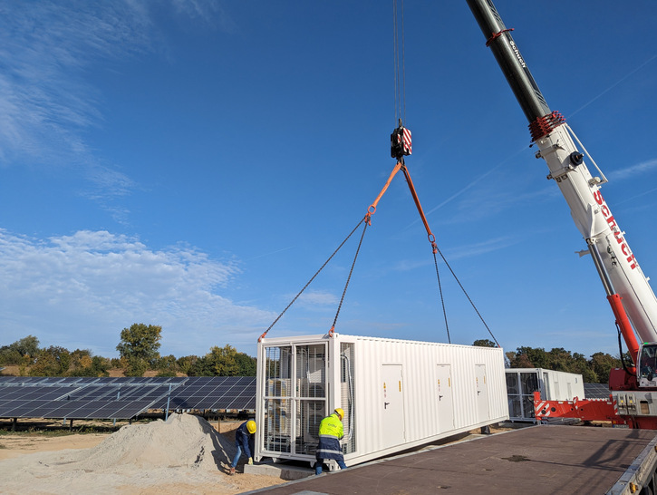 Der Batteriespeicher für den Solarpark Bruchsal wird angeliefert und mit einem Schwerlastkran auf das Fundament gehoben. - © EnBW
