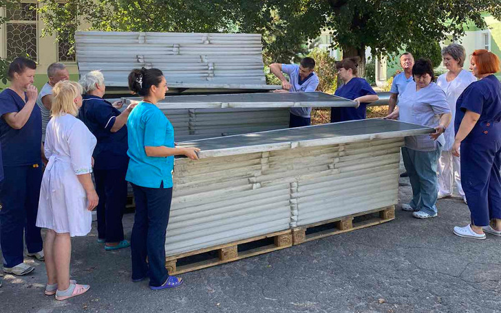 Das Personal der Kinderklinik in Charkiv packt selbst an und lädt die Solarmodule vom LKW.