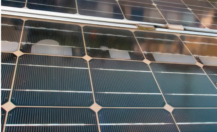 Nahaufnahme von Solarmodulen mit schwarzen Zellen und metallischen Gitterlinien, teilweise mit Staub oder Schmutz bedeckt. - © Foto: Secondsol