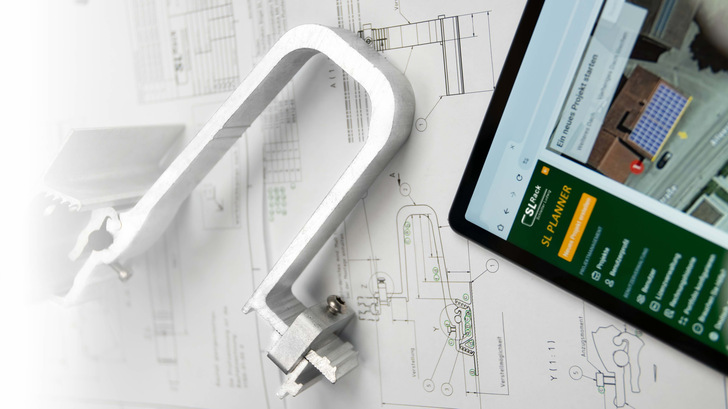 Auf einer weißen Fläche liegen eine Metallklammer, technische Zeichnungen und ein Tablet mit einer Site-Planer-App. - © SL Rack