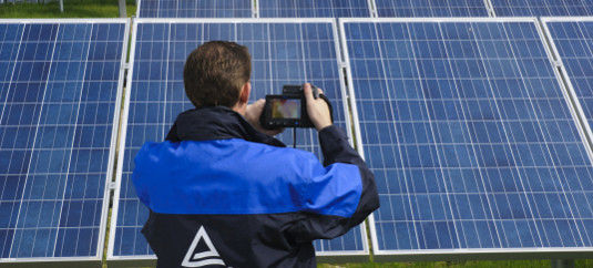 Mit der Wärmebildkamera erkennt der Prüfer, wo die Module zu heiß werden. Dort findet er die Fehler.