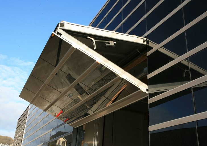 Um das Tor harmonisch in die Soalrfassade aus Holz und Dünnschichtmodulen zu integrieren, wurde die Verblendung als klappbares Element installiert.