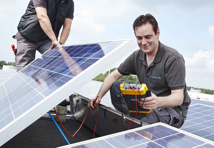 Servicetechniker bei der Wartung von Photovoltaikmodulen. - © Gildemeister
