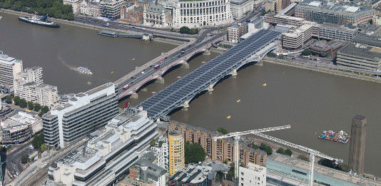Im vergangenen Jahr hat Solarcentury eine 800 Meter lange Solarstromanlage über eine Brücke über der Themse gebaut. Mit dem Strom wird der darunter liegende Bahnhof versorgt. - © Network Rail
