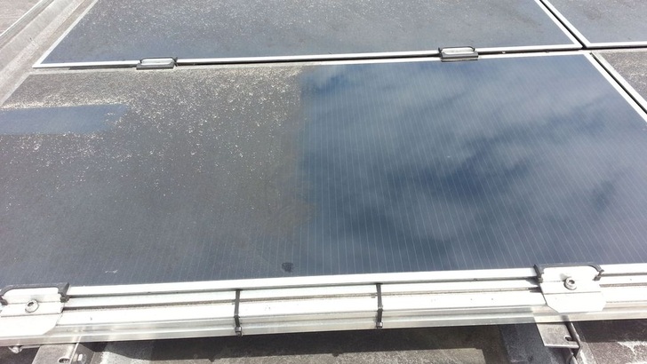 Links die verschmutzte Seite eines Moduls, rechts die gereinigte Fläche. Es ist leicht erkennbar, dass diese Anlage kaum noch Erträge bringt.