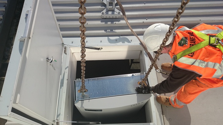 Installation eines gewerblichen Stringwechselrichters unter einer großen Dachanlage in England.