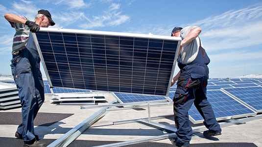 Installateure bringen Module aufs Flachdach. - © Sunenergy Europe
