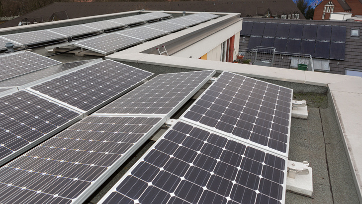 Die Ost-West-Ausrichtung der Anlage auf dem Flachdach garantiert maximlaen Eigenverbrauch. Die Anlage im Hintergrund musste sich optisch in das denkmalgeschützte Schrägdach einfügen.