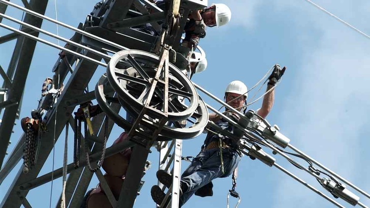 Techniker arbeiten an einer Leitung mit 380 Kilovolt.