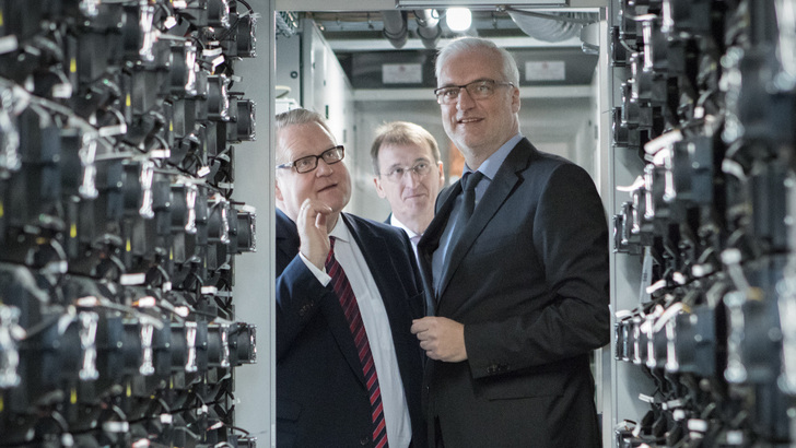 Der Vorsitzende der Geschäftsleitung der Steag (links) erklärt Wirtschaftsminister Garrelt Duin die Funktionsweise des Großspeichers, der von Nidec gebaut wurde.