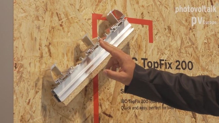 Michael Fleischmann, Entwickler bei IBC Solar, erklärt das neue Einlegesystem für private Ziegeldächer.