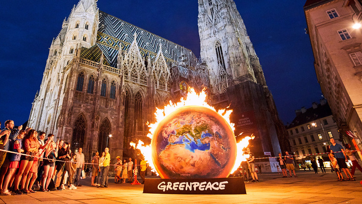 Die Erde heizt sich auf: Mit einer Aktion vor dem Stephansdom in Wien hat Greenpeace auf die Gefahr aufmerksam gemacht. Jetzt klagen die Umweltschützer vor dem Verfassungsgericht. - © Mitja Kobal/Greenpeace
