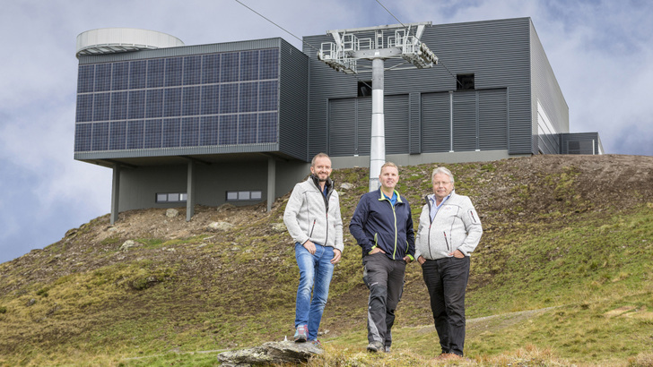 Stolz präsentiert David Kammerlander (Mitte) die Bergstation der neuen Godelbahn. Sie wird mit dem Strom aus der neuen Solaranlage angetrieben. - © Zillertal Arena
