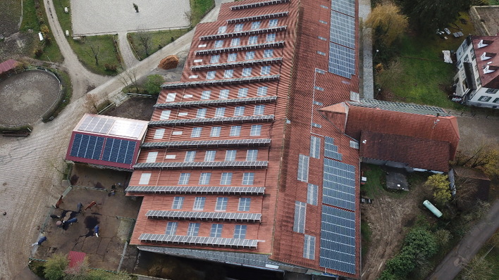 Ein Teil der neuen Module wurde dachparallel auf der Westseite (rechts) installiert, während die alte Anlage hoch aufgeständert nach Süden ausgerichtet ist.