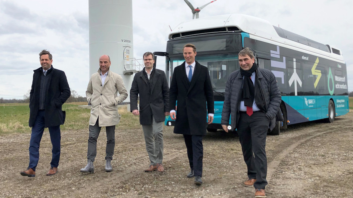 Der erste Wasserstoffbus ist schon da. Der Regelbetrieb soll spätestens Ende 2023 beginnen. Bis dahin ist könnte auch die Solaranlagen im vorhandenen Windpark stehen.
