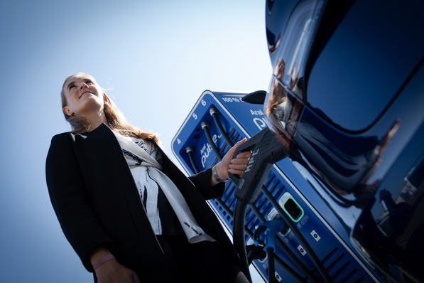 Eine Frau lädt ihr Fahrzeug mit Strom - bald auch bei Rewe!?
